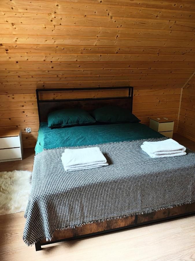Sypialnia z podwójnym łóżkiem pod drewnianym skosem