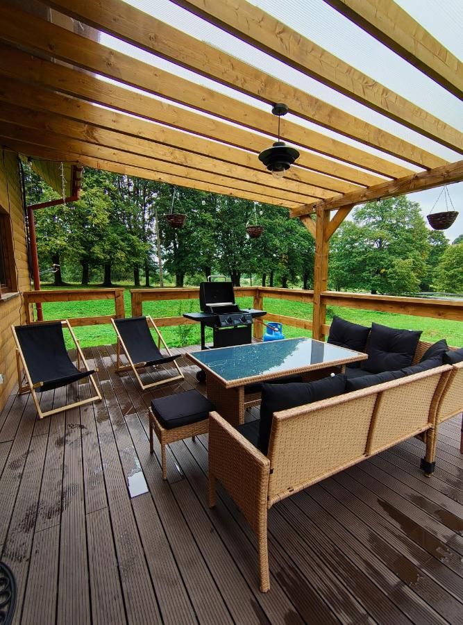 Taras pod drewnianą pergolą z rattanowymi meblami
